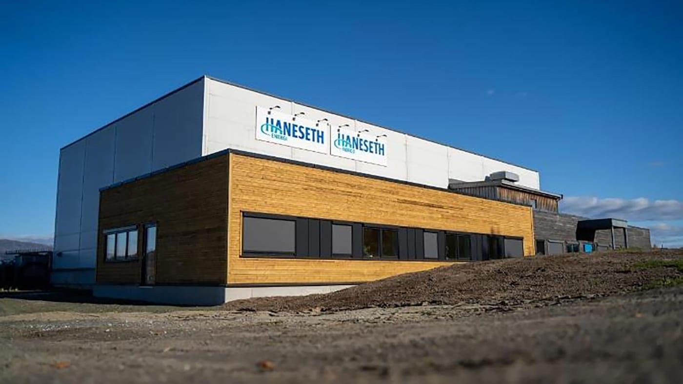 The office wing at Terminalveien 21, clad in timber and dark grey, with the Haneseth sign on the end wall